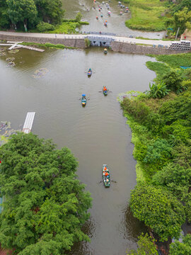 Tourist rowboats passing under a river bridge