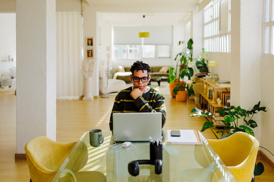 Man working focused on laptop at home office