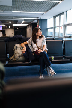 Woman Waiting at an Airport Gate With Luggage
