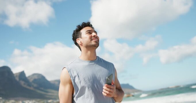 Earphones, walk and happy man with phone on beach, wellness podcast and playlist for morning exercise. Audio tech, streaming music and person smile for nature, listening and fitness guide for stroll