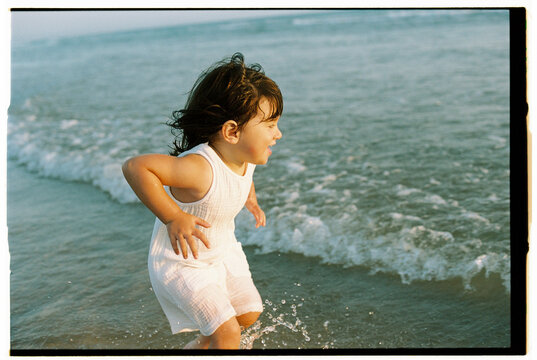 Excited child playing at edge of sea waves
