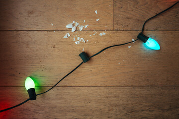 Broken Lightbulbs on Wooden Floor With Colorful Holiday Lights