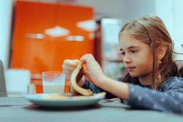 Little Girl Eating American Pancakes for Breakfast. Child has homemade delicious dessert craving for more 