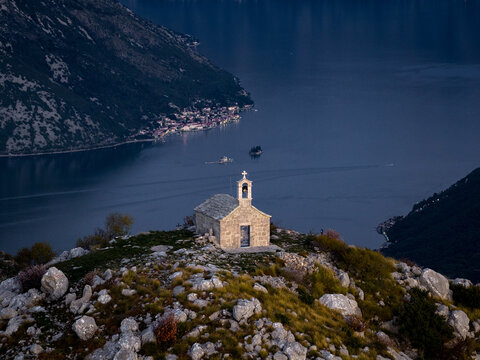 Church on a Hilltop Overlooking Water and Mountains at Dusk