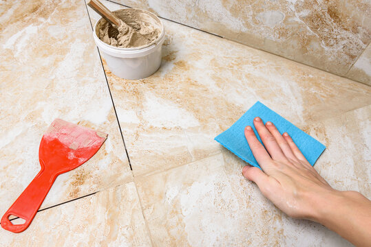 Worker washing tiles after jointing.