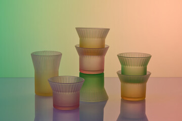 Colorful glass objects are arranged on a reflective surface