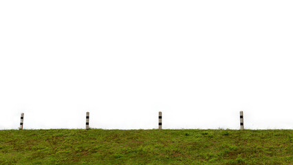 A beautiful rural landscape featuring a green grass field with a wooden fence stretching toward a horizon of rolling hills under a blue summer sky with soft white clouds