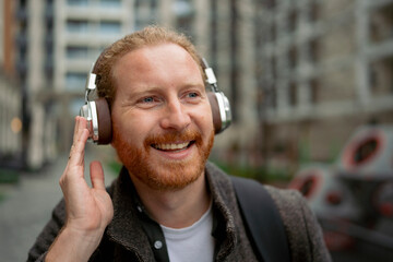 Man enjoys music while walking in an urban area during daytime
