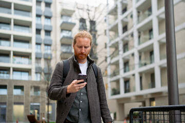 Man checks phone in urban courtyard