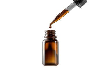 Amber Colored Essential Oil Dropping From Glass Dropper Into Dark Glass Bottle liquid