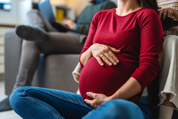 Closeup beautiful pregnant woman belly with her hands. Happy mother waiting for baby birth.