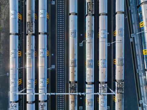 Aerial view of commuter trains parked at a train yard in Auckland, New Zealand. The trains are awaiting their next scheduled departure.