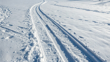 Fototapeta premium Tracks left in fresh snow during winter in a remote area with no trees or buildings