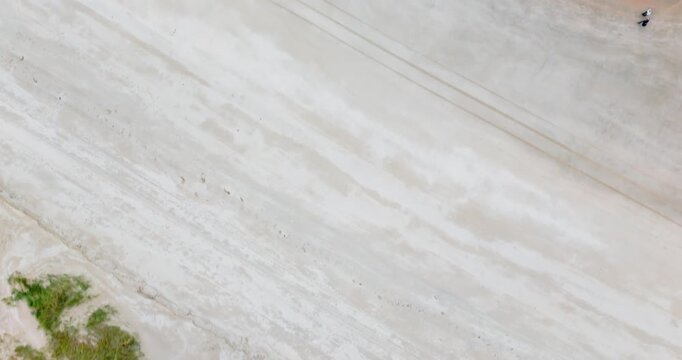 birdview drone flight over beach with walking humans very calm