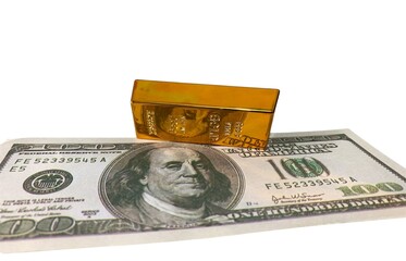 Single gold bar placed on a U.S. hundred-dollar bill, symbolizing wealth and tangible financial assets © MR HEPPY