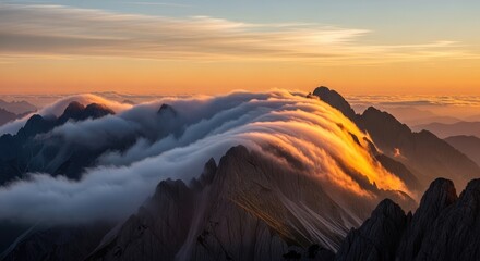 Sunset over majestic mountain range with clouds and golden light