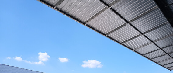 Metal sheet roof curve on blue sky. Modern construction, Metal ribbed arch span roof covering,...