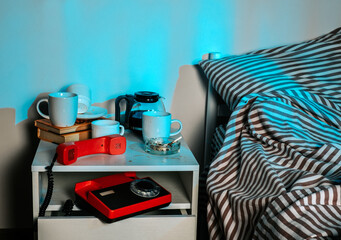 Messy bedside table with coffee and objects at night symbolizing insomnia