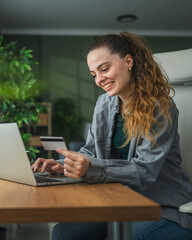 Woman making online payment with credit card on laptop