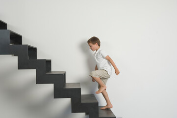 Child walking up modern staircase indoors with determination