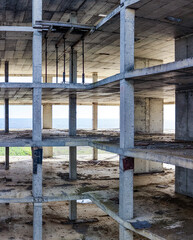Fototapeta premium View of a large empty concrete building structure with multiple floors near the sea during daylight hours