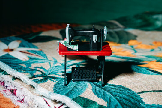 Sewing machine on colorful patterned fabric with green thread in quiet mood