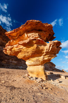 Stunning desert rock formation in mushroom shape towering over sand Saudi Arabia landscape under a clear blue sky