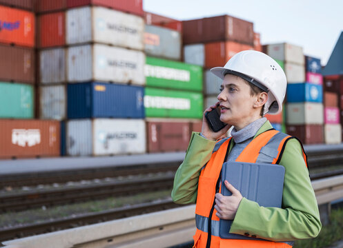 Businesswoman in safety gear managing logistics outdoors