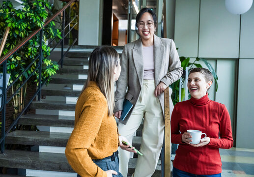 Coworkers having a casual meeting and conversation in a modern office
