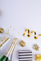 Overhead shot of christmas gifts and decoration by champagne on white background, copy space