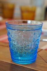 front view cold and cool water is in a blue glass, placed on a wooden table background, fresh, cool, ice, Clear, clean, beneficial, copy space