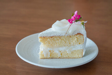 front view white coconut layer cake in white ceramic plate on wooden table background, dessert, food, fashion, decor, object, copy space