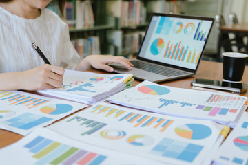 Asian female accountant businesswoman analyze using laptop to collect financial data in office. Business finance, tax and accounting concept.