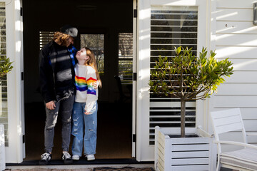 Father and tween daughter standing in the doorway