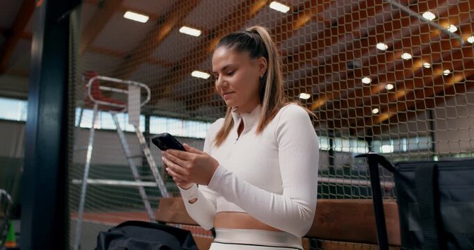 Close-up of the tennis player with a cell phone in her hands. .
