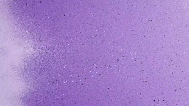 Purple speckled textured background with spray paint effect