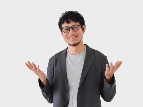 Man in a suit and glasses is smiling and pointing to the sky
