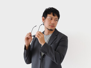 Man in a suit holding a pair of glasses