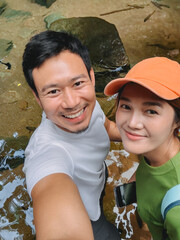 Closeup selfie of smiling Asian couple outdoors