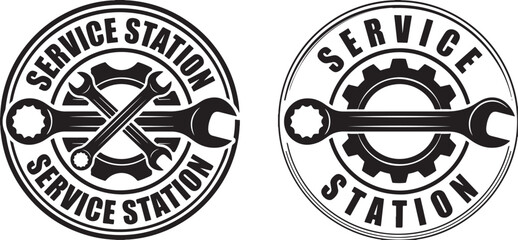 Two circular black and white service station emblems with crossed wrenches and gears
