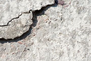 Fototapeta premium old plaster on the wall, cement, adhesive for screed. the old clay wall is crumbling. surface wall for vintage background. Wall texture, cracked plaster, grey cement floor, needs repair, restoration