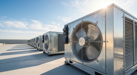 Air conditioning units arranged in rows on a rooftop during day with clear sky above and sunlight shining down