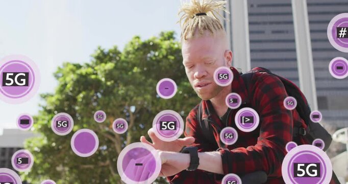 Animation of 5g texts over albino african american man scrolling on cellphone and using smartwatch