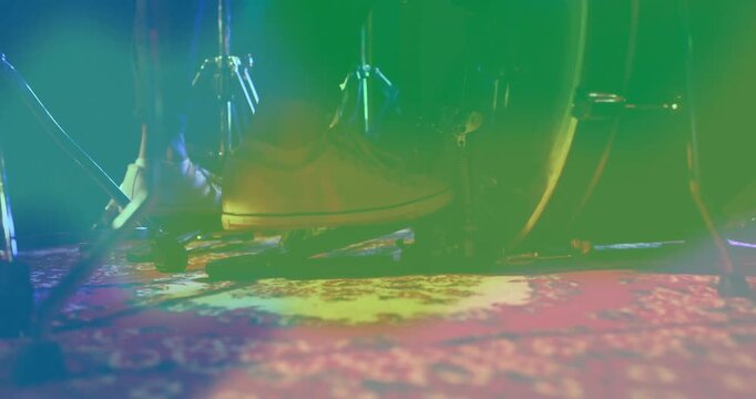 Drummer pressing drum pedal under colorful lights, adding animated sound waves for music production
