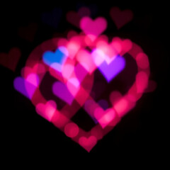 Vibrant and delicate heart shaped light bokeh with soft pink, blue, and purple glows, blending harmoniously to evoke a romantic and intimate mood, with gentle, feathery edges and a warm, ethereal