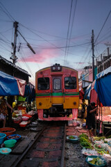 Experience the vibrant Maeklong Railway Market in Thailand at sunset
