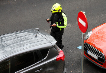 Agente de estacionamiento regulado ser y multa a coche mal aparcado en aparcamiento prohibido