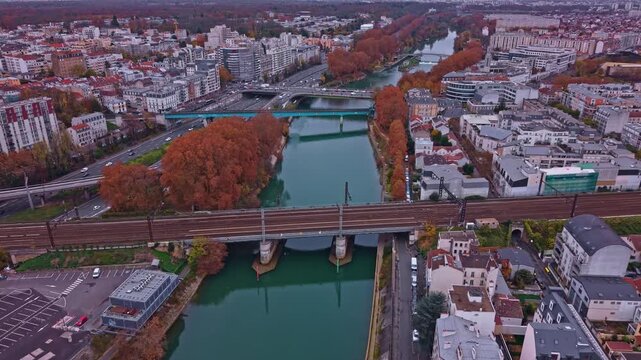 Tilted drone fly over Pont Ferroviaire and Marne River at the border of Alfortville and Saint-Maurice border, Paris, France