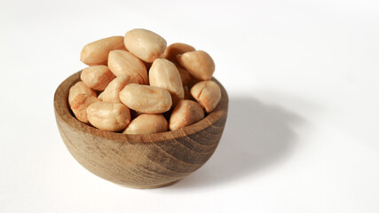 Obraz premium Roasted peanuts isolated on a white background, top view. Pile of shelled peanuts with a few scattered nuts on white background.