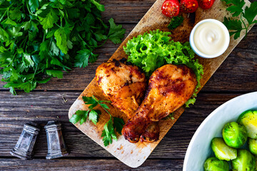 Roasted chicken drumsticks with mayonnaise on wooden table. Top view